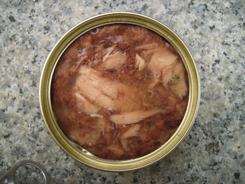 A wet dog food in a can with shredded meat.